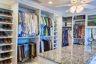 Large elegant gender-neutral walk-in closet photo in Orange County with open cabinets and white cabinets