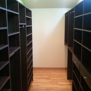 Foto de armario vestidor de hombre, clásico, pequeño, con armarios con paneles con relieve, puertas de armario de madera en tonos medios y suelo de madera clara