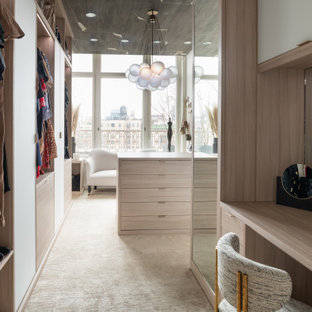 Diseño de armario vestidor de mujer, moderno, extra grande, con armarios con paneles lisos, puertas de armario beige, moqueta y suelo beige