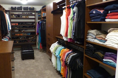 Example of a huge trendy gender-neutral walk-in closet design in Seattle with raised-panel cabinets and medium tone wood cabinets