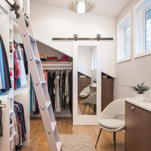 Neutrales Modernes Ankleidezimmer mit Ankleidebereich, flächenbündigen Schrankfronten, dunklen Holzschränken, braunem Holzboden und braunem Boden in Boston