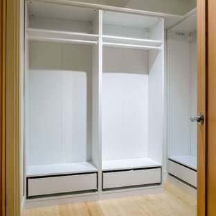 Esempio di una grande cabina armadio unisex american style con ante bianche e pavimento in bambù