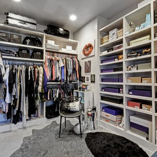 Immagine di uno spazio per vestirsi per donna design di medie dimensioni con ante lisce, ante in legno bruno, pavimento in cemento e pavimento grigio
