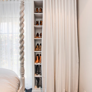 Immagine di un armadio o armadio a muro per donna chic con ante bianche e parquet scuro