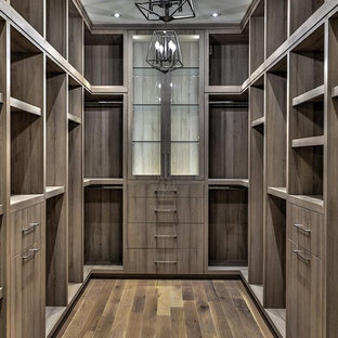 Imagen de armario vestidor unisex, nórdico, grande, con armarios con paneles lisos, puertas de armario de madera en tonos medios, suelo de madera oscura y suelo marrón