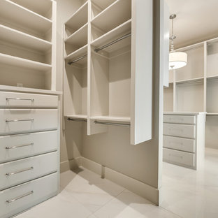 Idee per una grande cabina armadio unisex minimalista con ante a persiana, ante bianche, pavimento in marmo e pavimento bianco