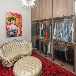 Immagine di un'ampia cabina armadio unisex contemporanea con ante di vetro, ante in legno chiaro, pavimento in legno massello medio e pavimento marrone