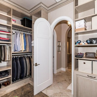 Ispirazione per un grande spazio per vestirsi unisex mediterraneo con ante con bugna sagomata e ante beige