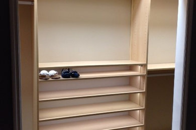 Imagen de armario y vestidor unisex clásico con armarios abiertos, puertas de armario de madera clara, moqueta y suelo gris