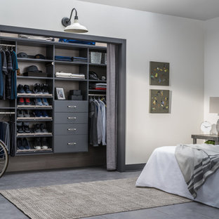 Cette photo montre un petit placard dressing tendance neutre avec des portes de placard grises, un placard sans porte, béton au sol et un sol beige.