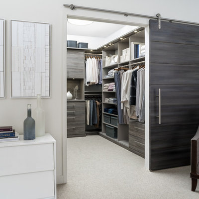 Walk-in closet - mid-sized transitional gender-neutral carpeted and beige floor walk-in closet idea in Charleston with flat-panel cabinets and brown cabinets