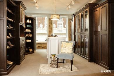 This is an example of a large contemporary gender neutral dressing room in Other with recessed-panel cabinets, dark wood cabinets, porcelain flooring and beige floors.