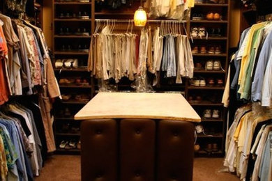 Foto de armario vestidor unisex grande con puertas de armario marrones y moqueta