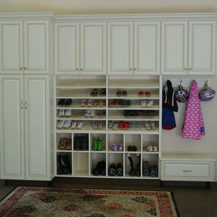 Idées déco pour un dressing room de taille moyenne et neutre avec des portes de placard blanches et un sol en bois foncé.