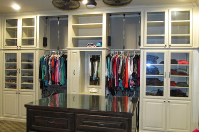 Walk-in closet - large transitional gender-neutral carpeted walk-in closet idea in New Orleans with raised-panel cabinets and white cabinets