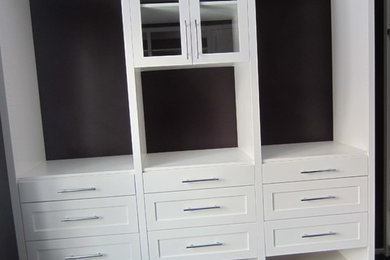 Photo of a medium sized traditional gender neutral walk-in wardrobe in New York with shaker cabinets, white cabinets, dark hardwood flooring and black floors.