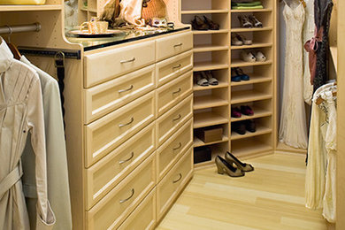 Ejemplo de armario vestidor grande con armarios con paneles empotrados, puertas de armario de madera clara y suelo de madera clara