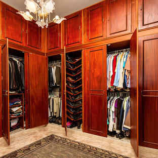 Foto di una grande cabina armadio unisex classica con ante con riquadro incassato, ante in legno scuro, pavimento con piastrelle in ceramica e pavimento marrone