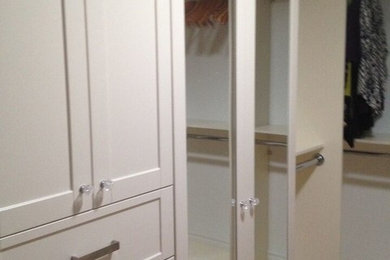 Example of a mid-sized transitional medium tone wood floor reach-in closet design in Toronto with glass-front cabinets and white cabinets