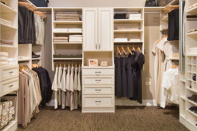 Foto de armario vestidor unisex clásico renovado de tamaño medio con armarios con rebordes decorativos, puertas de armario blancas, moqueta y suelo marrón