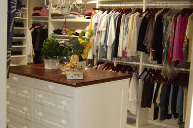 Example of a large classic women's walk-in closet design in Los Angeles with shaker cabinets and white cabinets