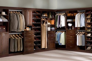 Example of a large classic gender-neutral carpeted walk-in closet design in Chicago with dark wood cabinets and raised-panel cabinets