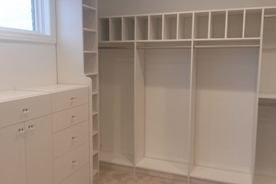 Example of a mid-sized minimalist gender-neutral carpeted dressing room design in Chicago with flat-panel cabinets and white cabinets