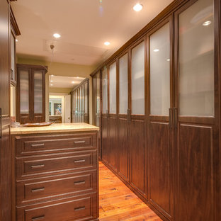 Imagen de armario vestidor unisex, de estilo de casa de campo, grande, con armarios con paneles con relieve, puertas de armario de madera en tonos medios y suelo de madera en tonos medios