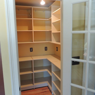 Imagen de armario vestidor tradicional, de tamaño medio, con puertas de armario beige y suelo de madera clara