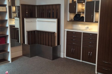 Foto de armario vestidor unisex moderno extra grande con armarios con paneles lisos, puertas de armario de madera en tonos medios, moqueta y suelo marrón