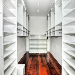 Foto på ett litet funkis walk-in-closet för könsneutrala, med öppna hyllor, vita skåp och mörkt trägolv