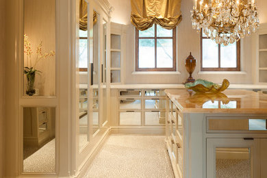 На фото: большая гардеробная комната в классическом стиле с ковровым покрытием для женщин с