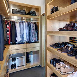 Idee per una grande cabina armadio unisex minimal con ante lisce, ante in legno scuro, moquette e pavimento nero