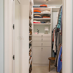 Foto di una cabina armadio unisex stile shabby di medie dimensioni con ante lisce, ante bianche, moquette e pavimento beige