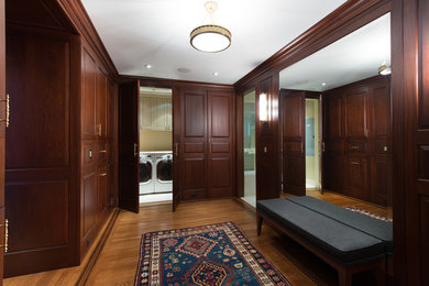 Inspiration for a huge timeless gender-neutral medium tone wood floor dressing room remodel in Philadelphia with raised-panel cabinets and dark wood cabinets