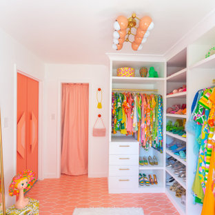 Idée de décoration pour un grand dressing vintage pour une femme avec des portes de placard blanches, un sol en carrelage de céramique et un sol rose.