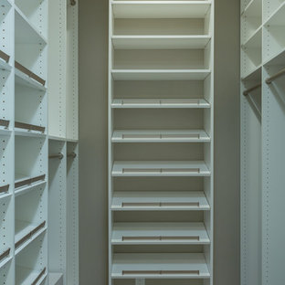 Réalisation d'un dressing tradition de taille moyenne et neutre avec un placard sans porte, des portes de placard blanches, un sol en bois foncé et un sol marron.