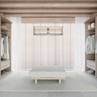 Inspiration för moderna garderober, med öppna hyllor, skåp i ljust trä, kalkstensgolv och beiget golv