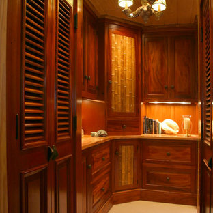 Imagen de armario vestidor unisex, exótico, de tamaño medio, con puertas de armario de madera en tonos medios, armarios con paneles con relieve y moqueta