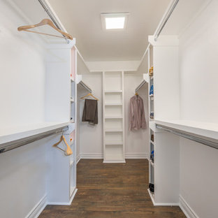 Ejemplo de armario vestidor unisex, minimalista, grande, con armarios abiertos, puertas de armario blancas, suelo de madera en tonos medios y suelo marrón