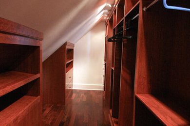 Ejemplo de armario vestidor unisex tradicional grande con puertas de armario de madera oscura y suelo de madera en tonos medios
