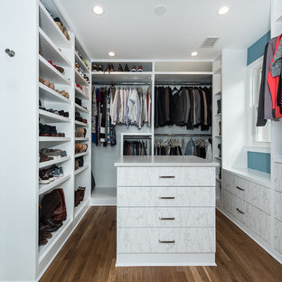 Diseño de armario vestidor unisex, romántico, grande, con armarios con paneles lisos, puertas de armario blancas, suelo de madera en tonos medios y suelo marrón