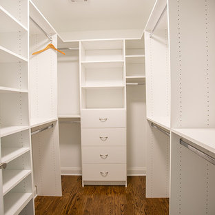 Klassisk inredning av ett mellanstort walk-in-closet för könsneutrala, med vita skåp, mellanmörkt trägolv och släta luckor
