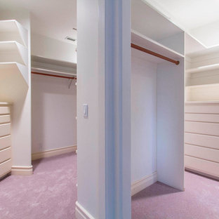 Idée de décoration pour un grand dressing design neutre avec un placard à porte plane, des portes de placard blanches, moquette et un sol rose.