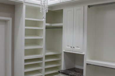 Walk-in closet - mid-sized shabby-chic style carpeted walk-in closet idea in Other with raised-panel cabinets and white cabinets