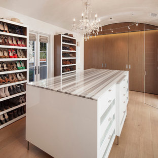 Foto di una cabina armadio unisex mediterranea con parquet chiaro, ante bianche e pavimento beige