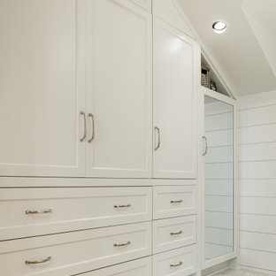 Imagen de armario y vestidor abovedado, costero, de tamaño medio, con armarios estilo shaker, puertas de armario blancas y suelo de madera en tonos medios