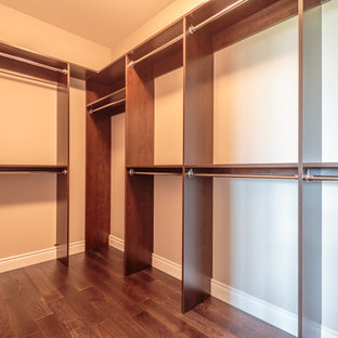 Ispirazione per una grande cabina armadio unisex stile americano con ante lisce, ante marroni e parquet scuro