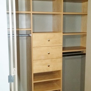 Diseño de armario unisex, moderno, pequeño, con armarios con paneles lisos, suelo de madera en tonos medios y puertas de armario beige
