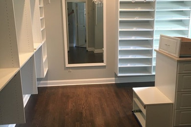 Example of a large transitional gender-neutral dark wood floor and brown floor dressing room design in DC Metro with raised-panel cabinets and white cabinets